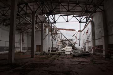 an abandoned hangar with a ruined roof