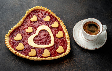 coffee, heart-shaped cake, a gift with a red ribbon for Valentine's Day on  stone background, with copy space for your text. breakfast concept on  saint's day  Valentine.