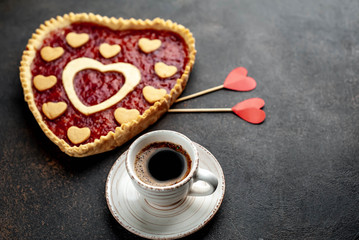 coffee, heart-shaped cake, a gift with a red ribbon for Valentine's Day on  stone background, with copy space for your text. breakfast concept on  saint's day  Valentine.