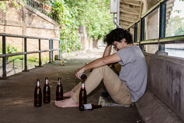 Portrait The man was sadly drinking liquor under the bridge.