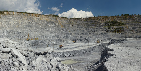 Panorama of a large quarry for limestone mining in sunny weather. Mining industry.