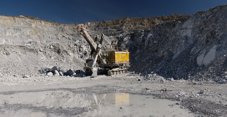 Large quarry excavator in a limestone quarry, panorama. Heavy equipment.