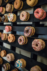 donuts hanging on DIY wall for wedding desserts