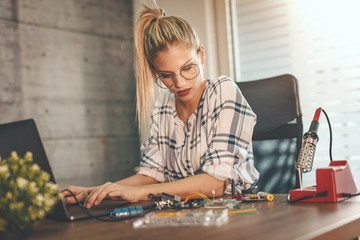 Female Engineer Testing Circuit Board In Her Office