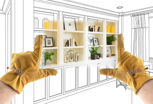 Male Contractor Hands Framing Completed Section of Built In Shelving Over Drawing