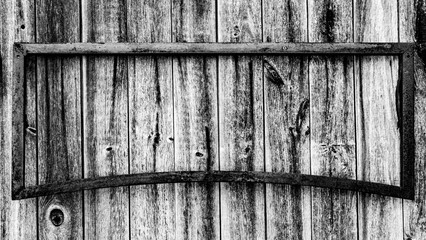 A black and white rendering of an old, long horizontal, rusted iron empty frame on barn wood background, great for graphic overlay and text framing