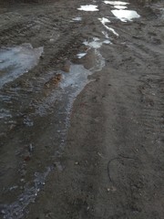 Staroselskaya road covered with ice with mud and slush in cold frosty weather.