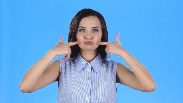 Young woman puffed out her cheeks. Slow motion