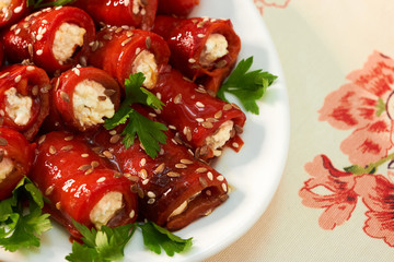 Rolls from bell red pepper with soft cheese on the plate