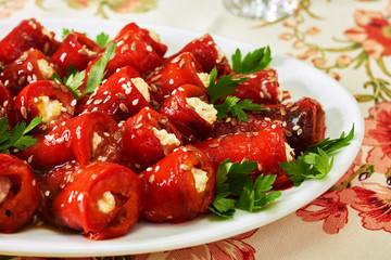 Rolls from bell red pepper with soft cheese on the plate