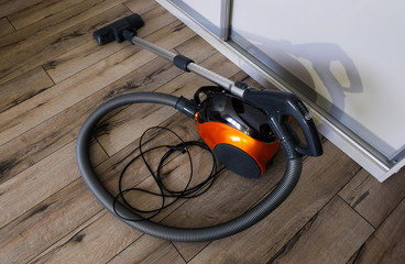 A vacuum cleaner for home cleaning on a wooden floor. Selective focus. Horizontal orientation.