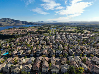 Aerial view of upper middle class neighborhood with identical residential subdivision houses during sunny day in Chula Vista, California, USA.