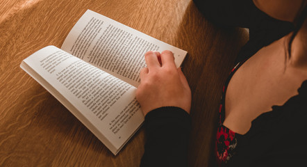 Naklejka premium Young person studing a novel book for teaching online course to her follower on internet - Smart digital girl reading a book to learn new skills in marketing business