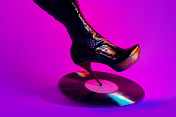 Vinyl record under the heel of a female shoe. Creative concept of a hot bachelorette party.