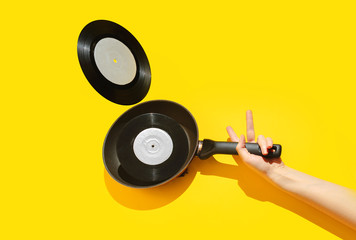 Vinyl record in a pan on a yellow background. Creative concept of a vibrant morning. - 314127014