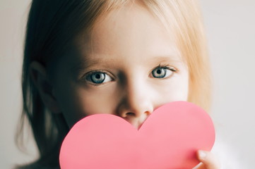 Little girl with Valentine. Child holding paper heart. Close up photo of little child. Little girl with a heart. St Valentines day. Love - 314127206