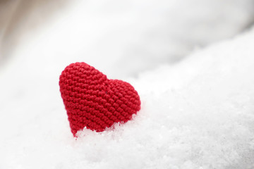 Valentine's day, red knitted heart in the snow. Background for romantic event, celebration or winter weather	