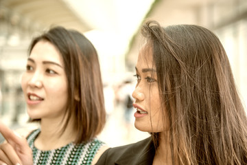 Two female friends visiting city mall for shopping season