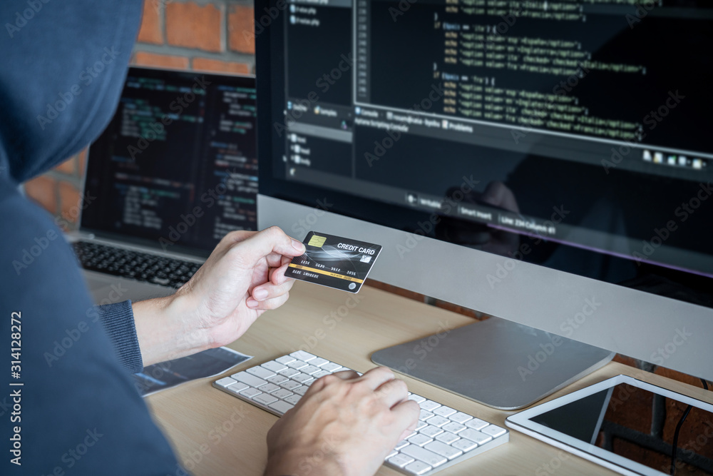 Leinwandbilder Computer hacker or cyber attack concept, Dangerous hooded hacker using multiple computers typing bad data into online system the access with a virus to infect steal information