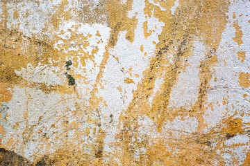 Painted in yellow and white concrete old damaged texture, wallpaper and background, close-up. Grunge rusty design, decoration and exterior or interior details concept