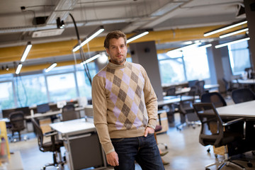 Fototapeta na wymiar Portrait shot of handsome businessman wearing casual clothes while standing in the office