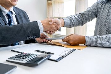 Bribery and corruption concept, bribe in the form of dollar bills, Businessman shaking hands and giving hides money while making deal to agreement a contract