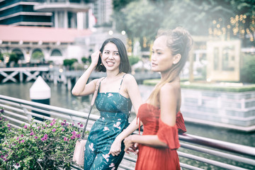 Two beautiful asian girls outdoor at sunset relaxing around the city