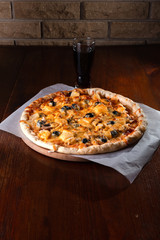 Pizza on a wooden dark background in a bar