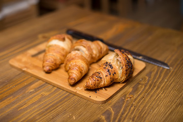 Tasty buttery croissants on old wooden table