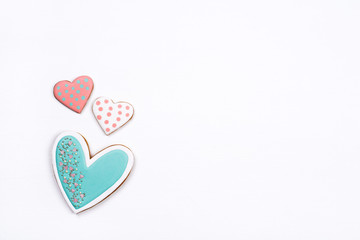 Gingerbread cookies with frosting in the shape of a heart on white background. Valentines day concept. Flat lay, top view, copy space for text.
