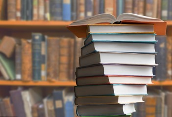 Old stacked books on blurred library background