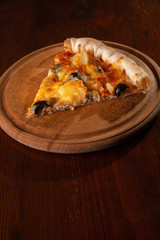 Pizza on a wooden dark background in a bar