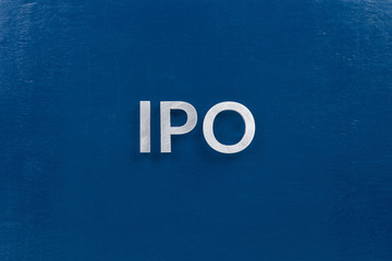 the abbreviation ipo - initial public offering - laid with silver metal letters on classic blue...