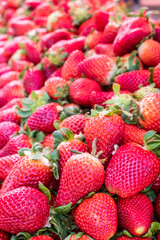 Big pile of fresh juicy red strawberries on fruit market