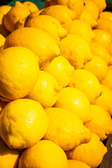 Big pile of fresh juicy yellow lemons on fruit market