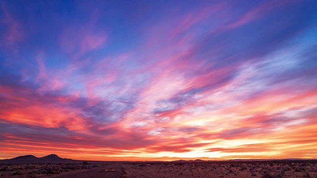 Fiery magenta, orange, and classic blue sunrise in desert, Timelapse