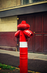 Red fire hydrant on a sidewalk of a street