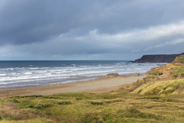 stormy clouds and waves at Widemouth Bay , Bude in Cornwall