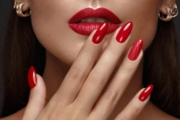 Fotobehang Nagelstudio Mooi meisje met een klassieke make-up en rode nagels. Manicure ontwerp. Mooi gezicht.