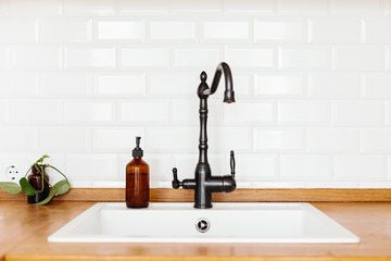 Kitchen with white sink and black faucet wooden countertop