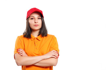 a young woman in an orange Polo shirt with her arms crossed looks at the camera and smiles.