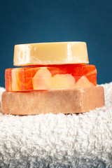 Bath accessories, handmade soap and white towel on blue background. Aromatherapy organic concept 