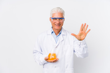 Mature chemical man isolated smiling cheerful showing number five with fingers.