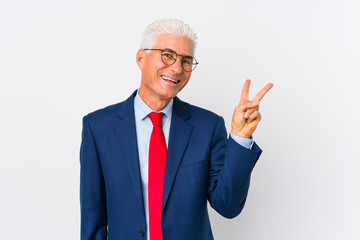Middle aged caucasian business man isolated joyful and carefree showing a peace symbol with fingers.
