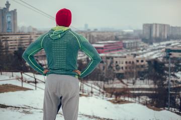 Athletic man standing outdoors looking at the cityscape