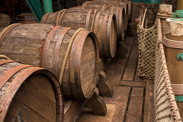 Large wine wooden barrels on a wooden floor tied with a large rope.