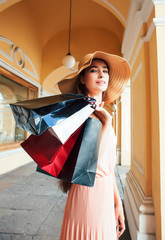 young pretty smiling woman in hat with bags on shopping at store gallery, lifestyle people concept