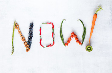 Healthy foods arranged to spell the word now.