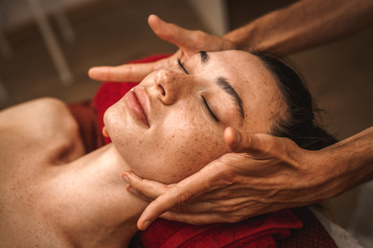 Alternative Medicine. Therapist Healing Lying Woman Peaceful Close-up Doing Head Ayurvedic Massage Pressing On Lymph Nodes