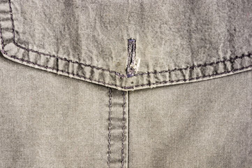 clothing items stonewashed cotton fabric texture with seams, clasps, buttons and rivets, macro